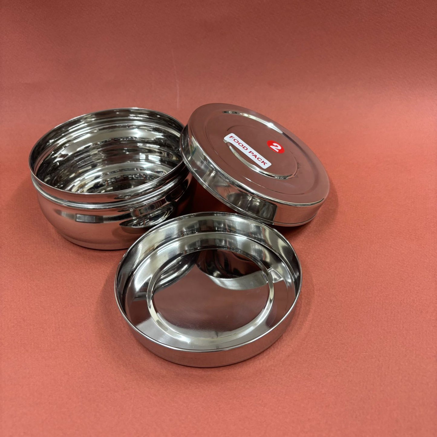 Spacious bulging stainless steel lunchbox with secure lid for carrying meals