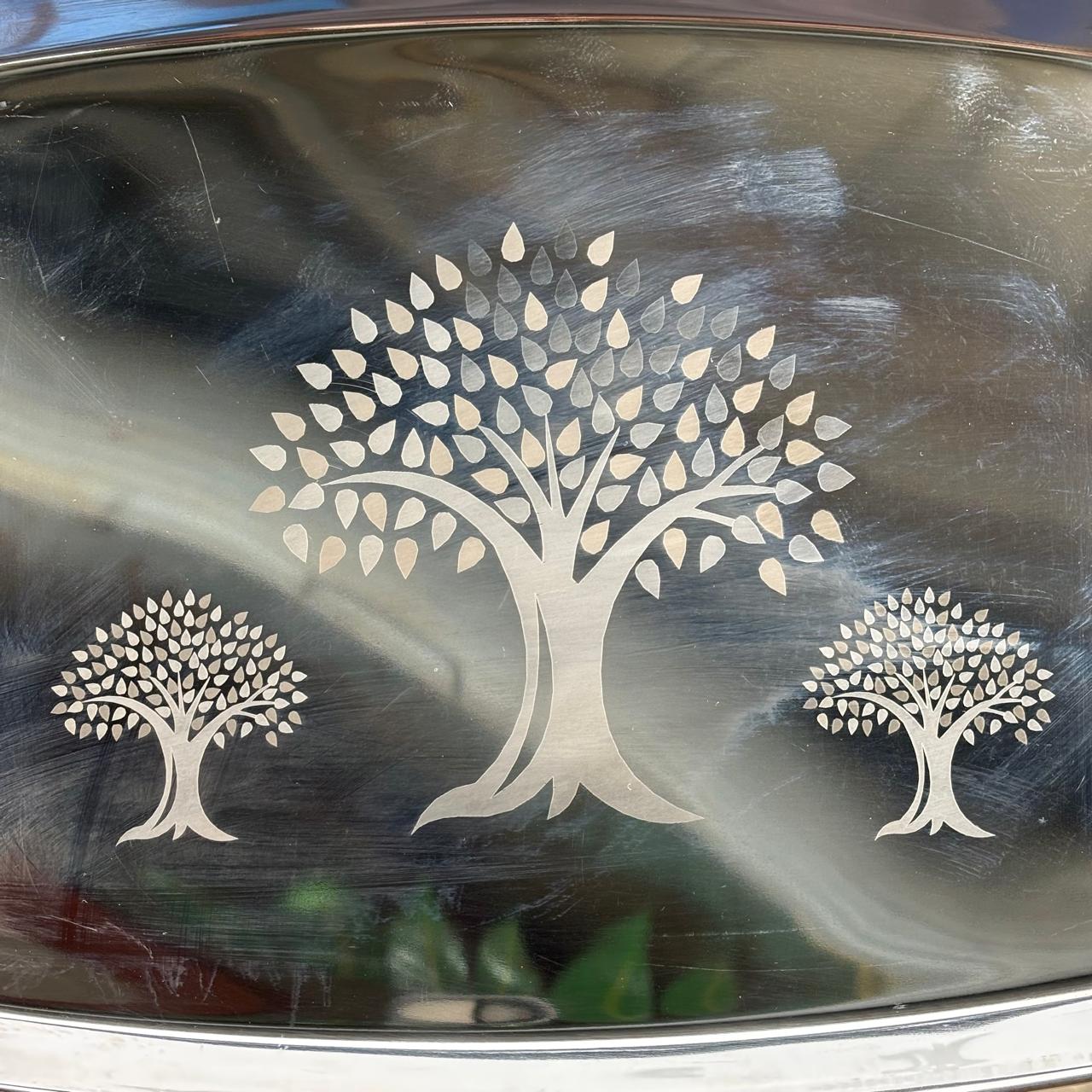Close-up view of tree engraving on stainless steel serving tray