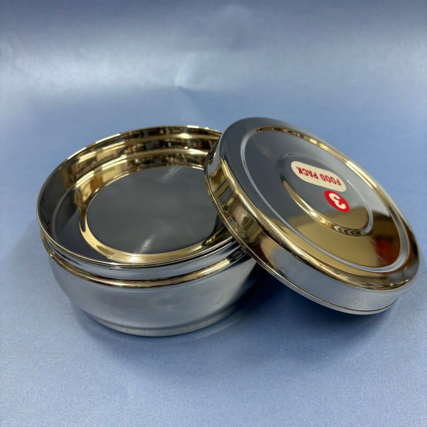 Spacious bulging stainless steel lunchbox with secure lid for carrying meals