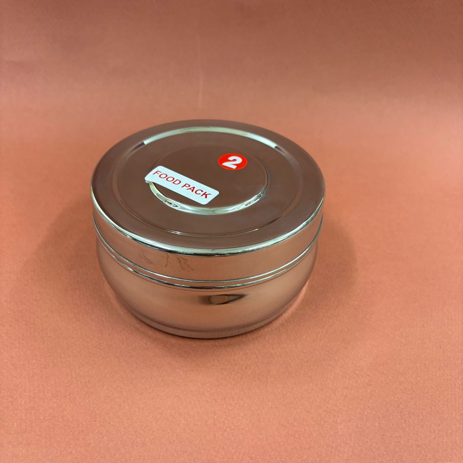 Spacious bulging stainless steel lunchbox with secure lid for carrying meals