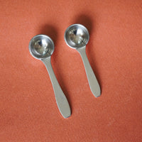 Pair of stainless steel oil spoons – top view with smooth handles