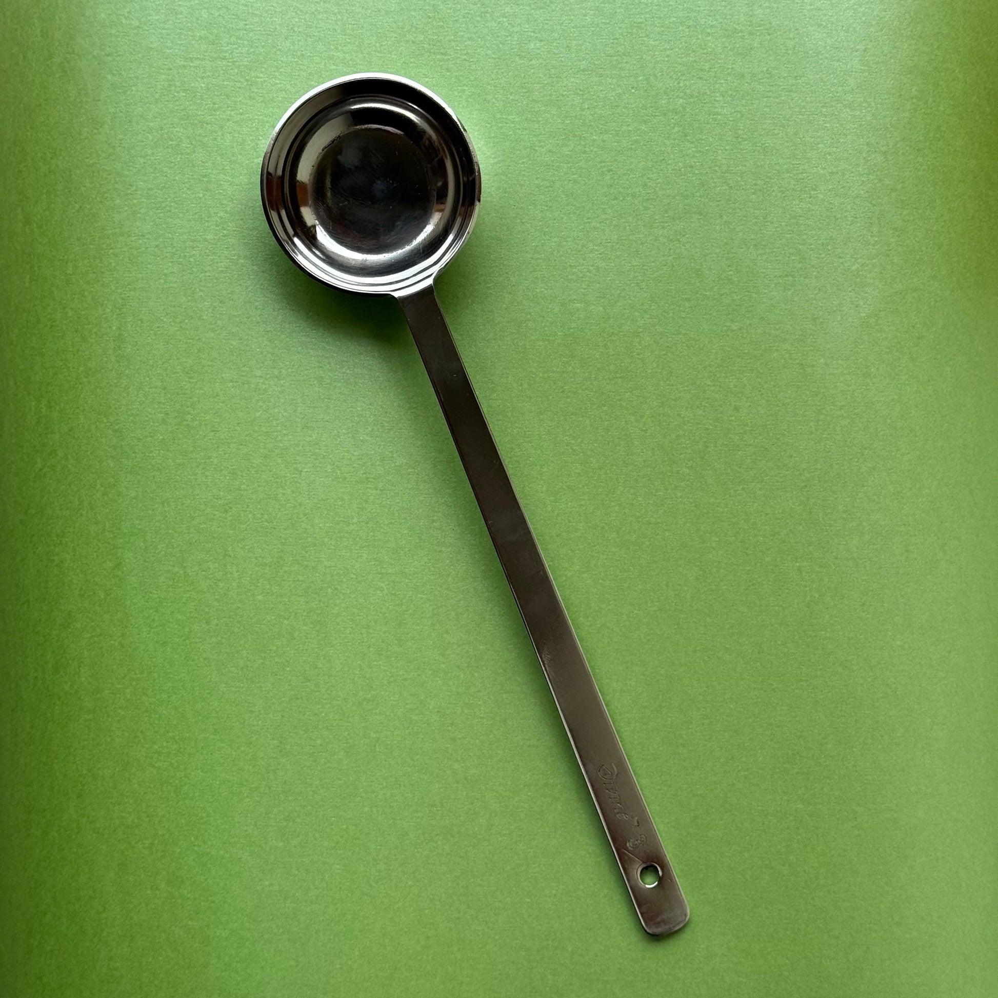  Stainless steel dosa batter ladle being used to pour dosa batter on a taw
