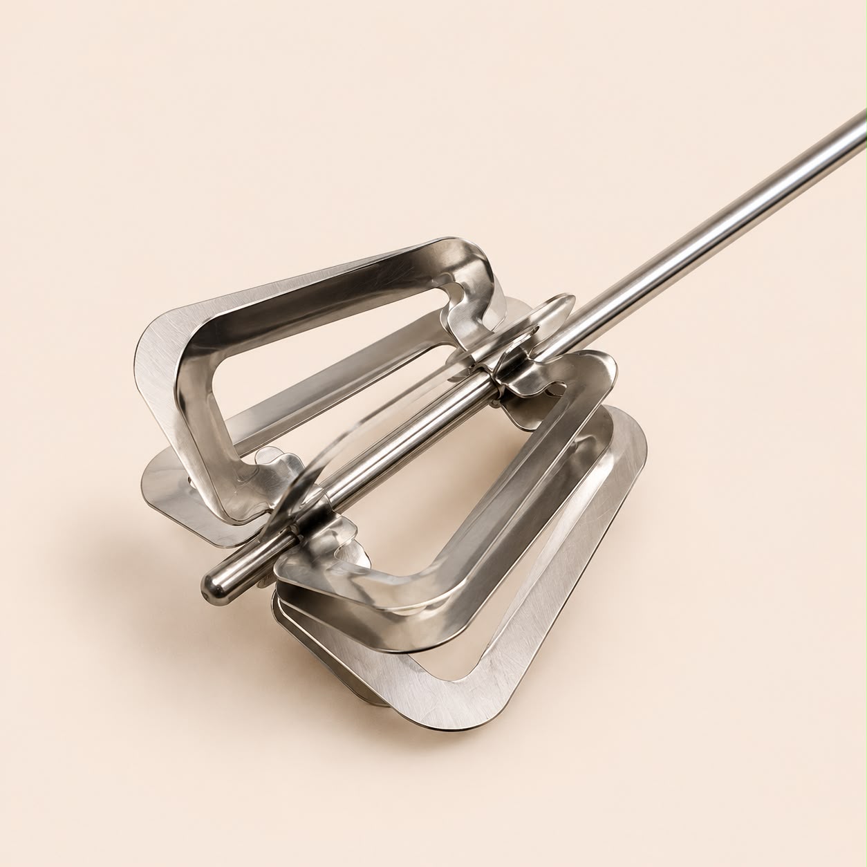 Close-up of stainless steel mechanical whisk mixing head.
